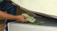 An image of an old person grabbing money from beneath a mattress
